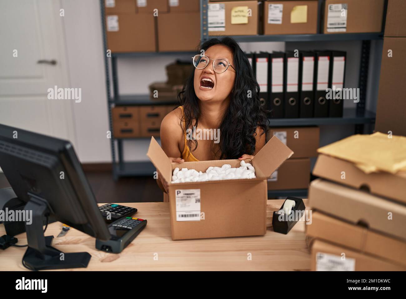 Young asian woman working at small business ecommerce angry and mad ...