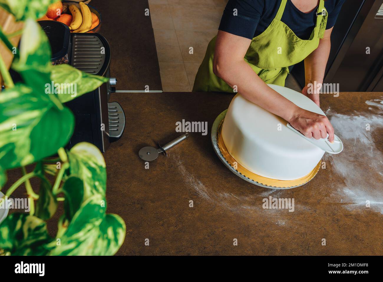 Unrecognisable woman in bakery decorating wedding cake with white fondant. DIY, sequence, step by step, multiple image. Stock Photo