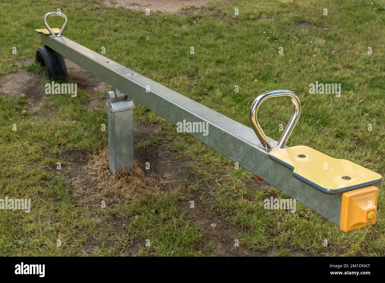 New seesaw on a children's playground with lawn Stock Photo