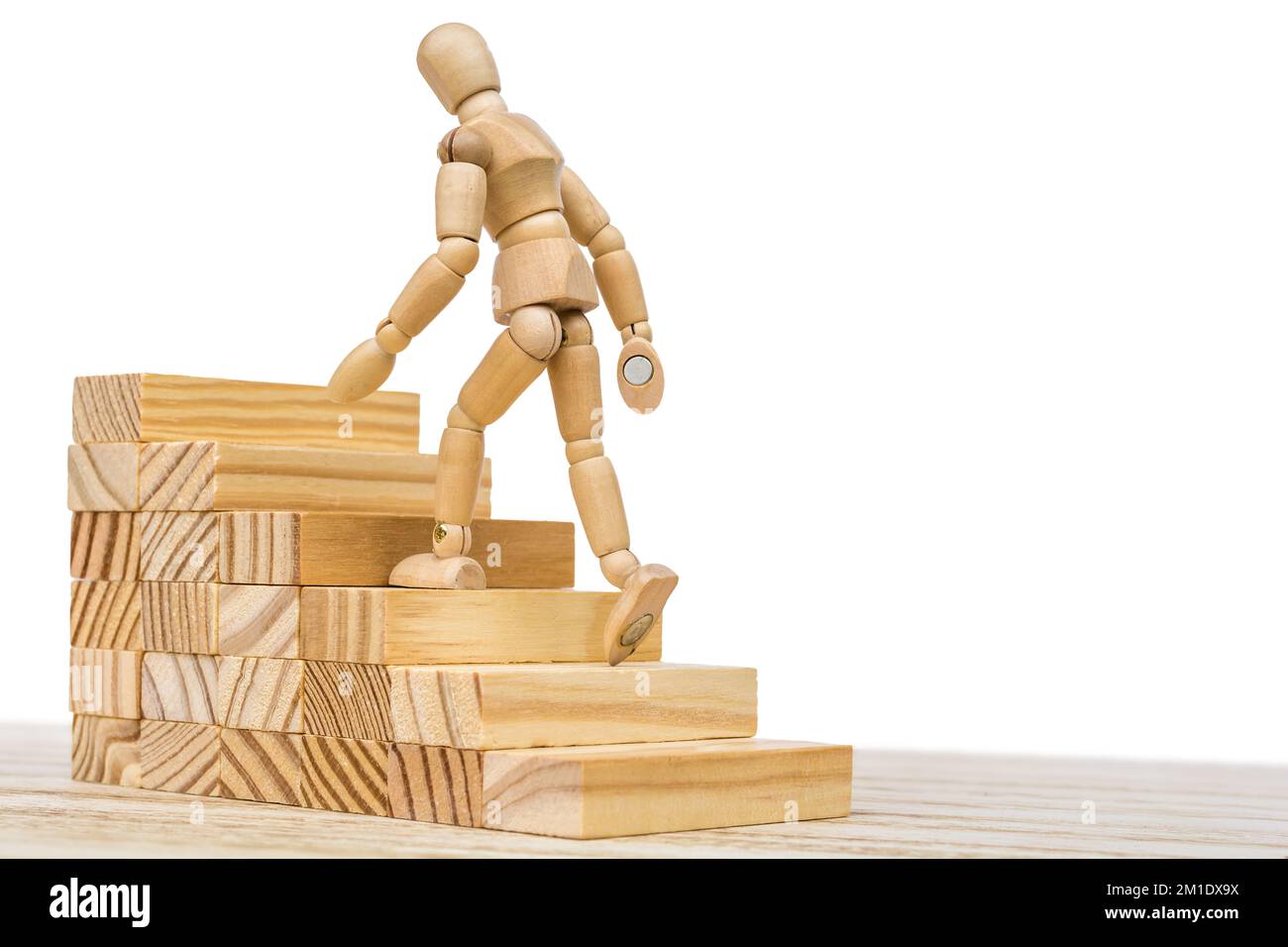 Wooden figure climbs a wooden staircase as a symbol of career advancement Stock Photo