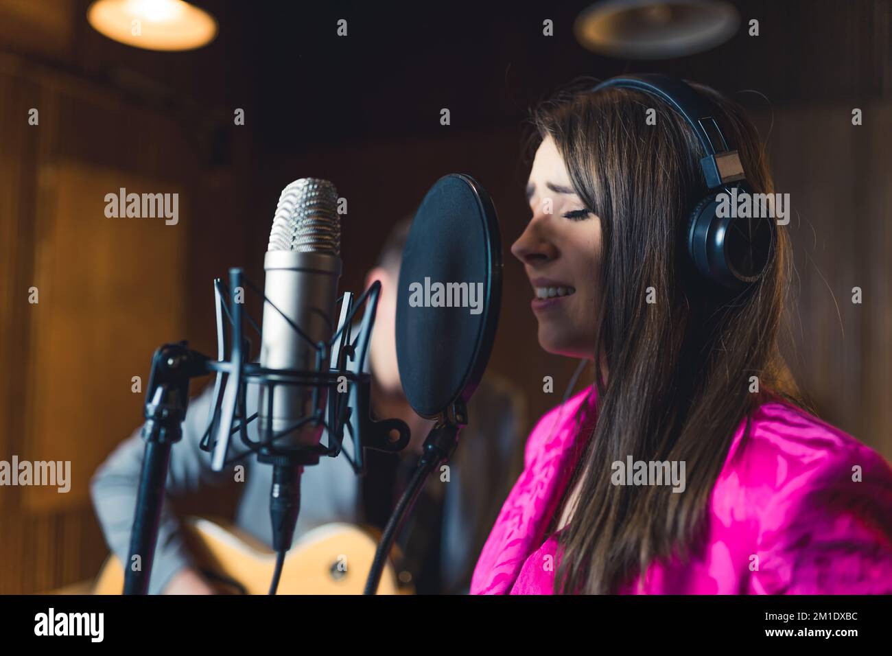 Portrait of vocalist recording a song with headphones on. Closeup