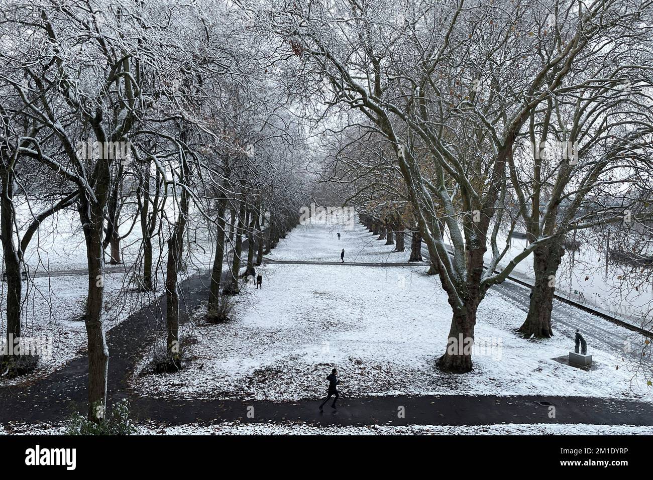 A man jogs in the snow in a park in London, Britain, December 12, 2022. REUTERS/Lucy Nicholson Stock Photo