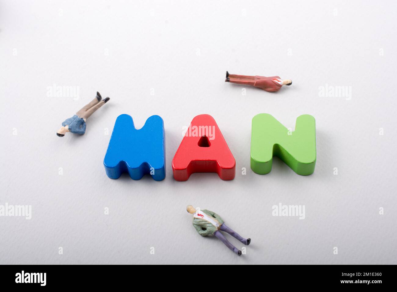 Tiny figurine of men beside colorful wooden letters say MAN Stock Photo ...