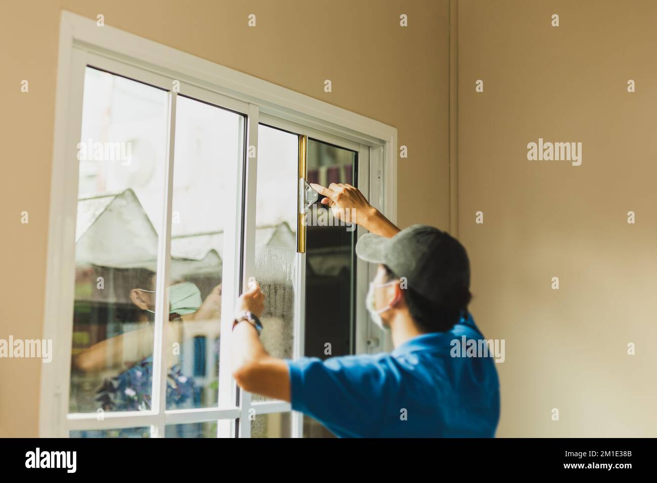 Worker use scraper cleaning window before installing tinting window