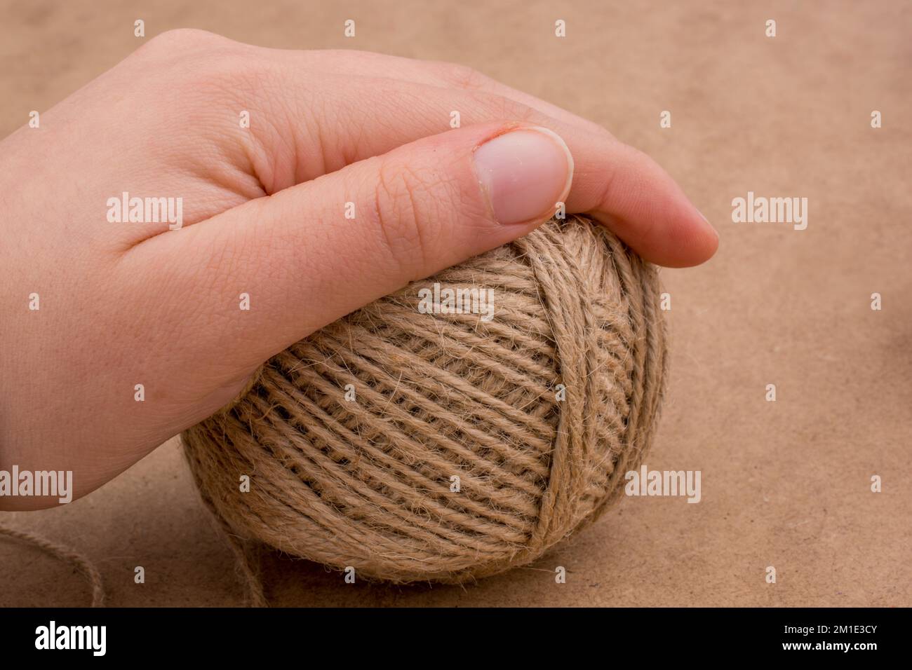 Spools of thread in hand isolated on a brown background Stock Photo