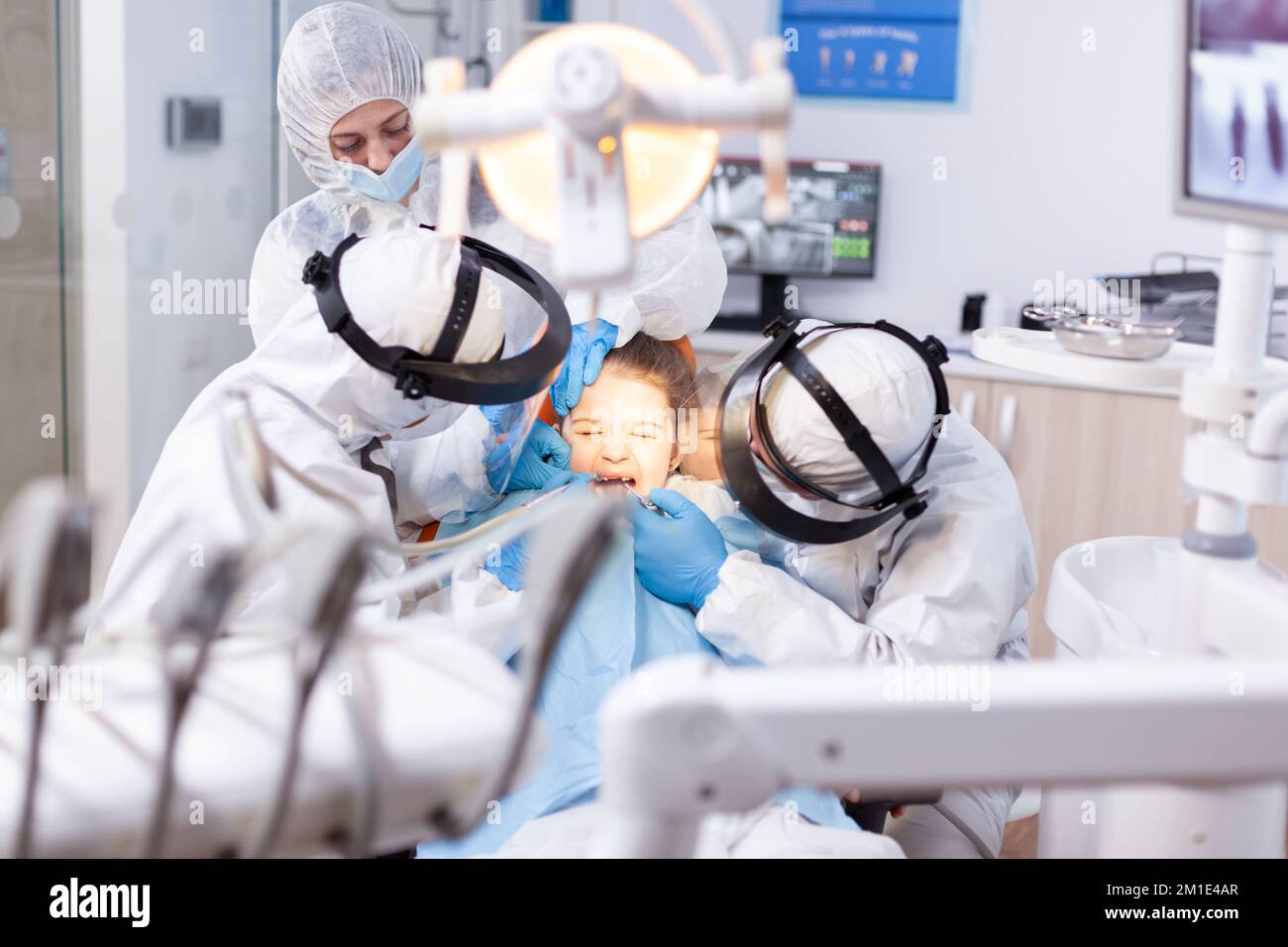 Little girl screaming in the course of painfull cavity treatment at