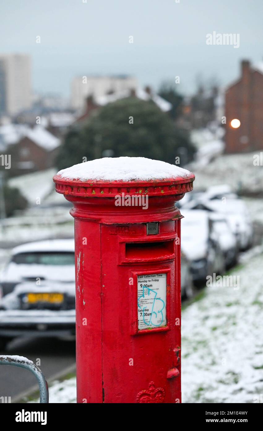 Brighton UK 12th December 2022 - Snow on a red post box near Brighton Racecourse this morning as the freezing weather is forecast to last for the next few days throughout Britain . : Credit Simon Dack / Alamy Live News Stock Photo