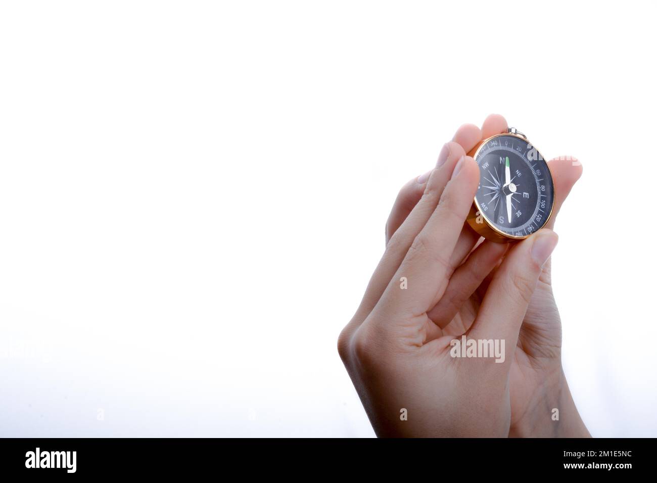 Isolated compass in child's hand on a white background Stock Photo