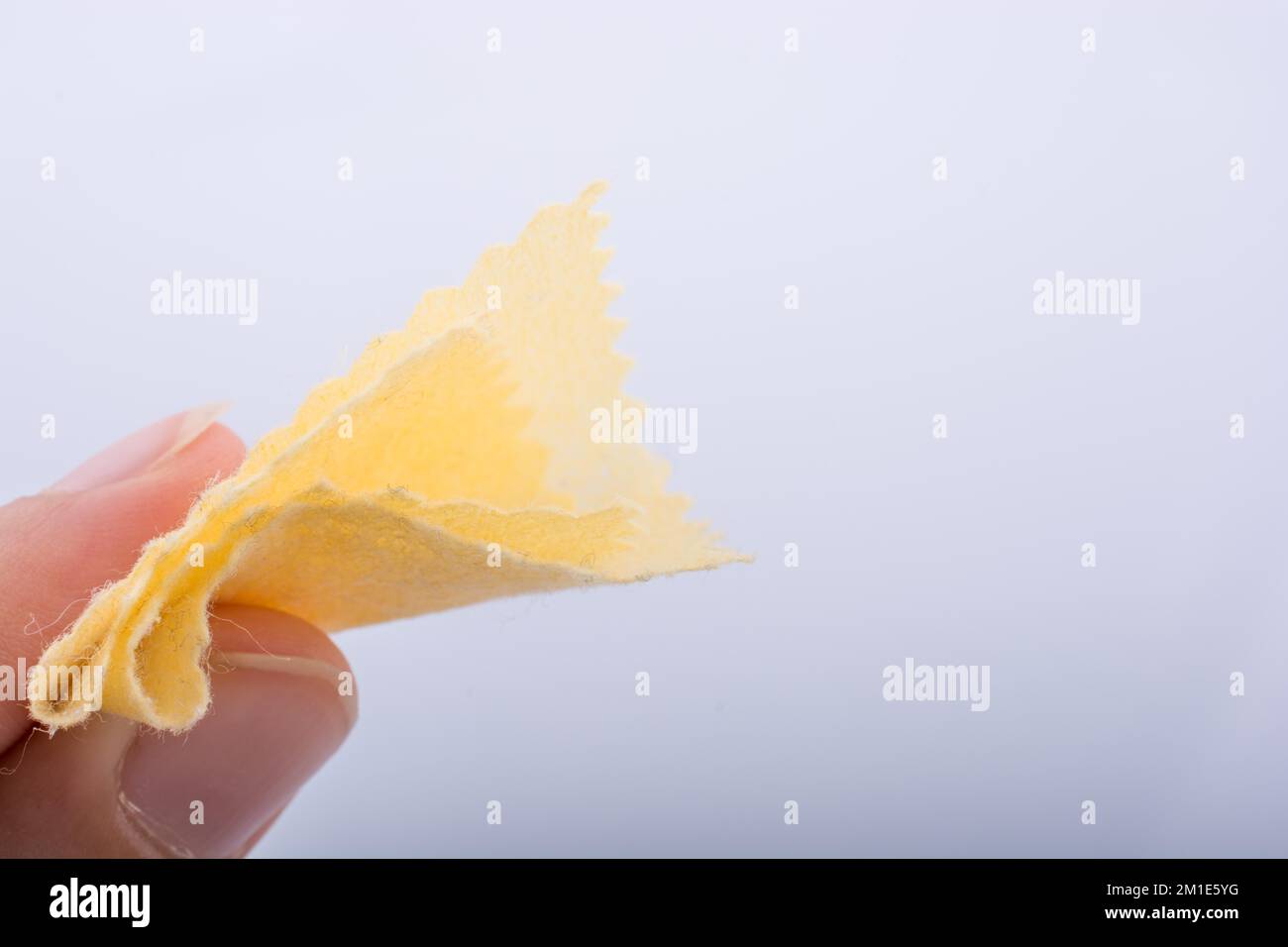 Yellow color mini handkerchief in hand on white background Stock Photo ...