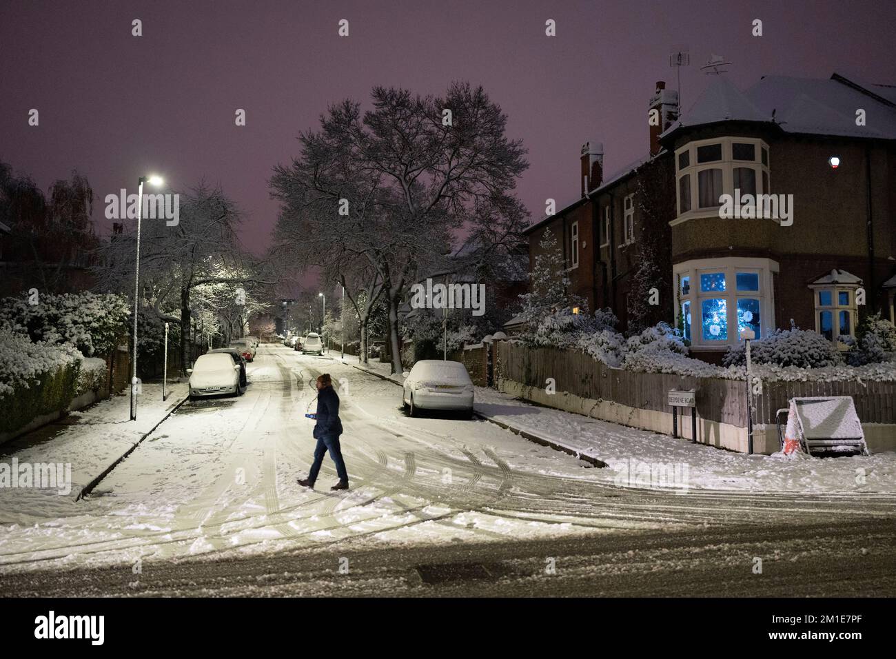 A commuter walks past residential properties after low temperatures and overnight snowfall on south London homes on Ruskin Park in SE24, on 12th December 2022, in London, England. Stock Photo