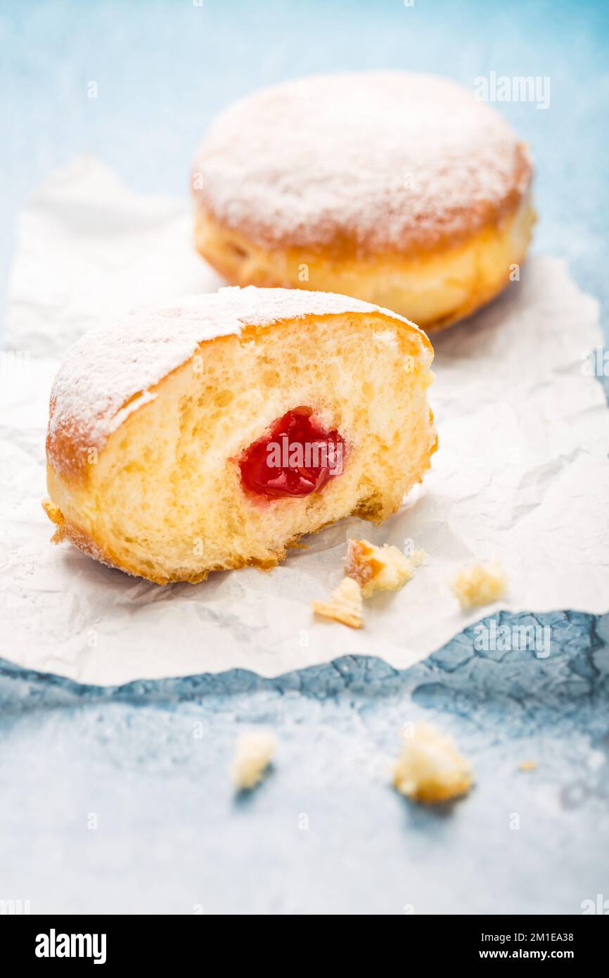 German donuts - berliner filled with strawberry jam with icing sugar Stock Photo