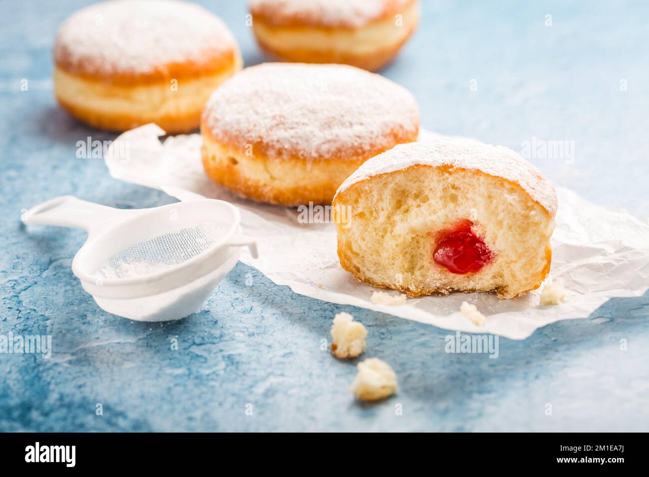 German donuts - berliner filled with strawberry jam with icing sugar Stock Photo