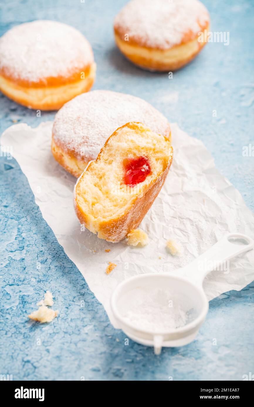 German donuts - berliner filled with strawberry jam with icing sugar Stock Photo