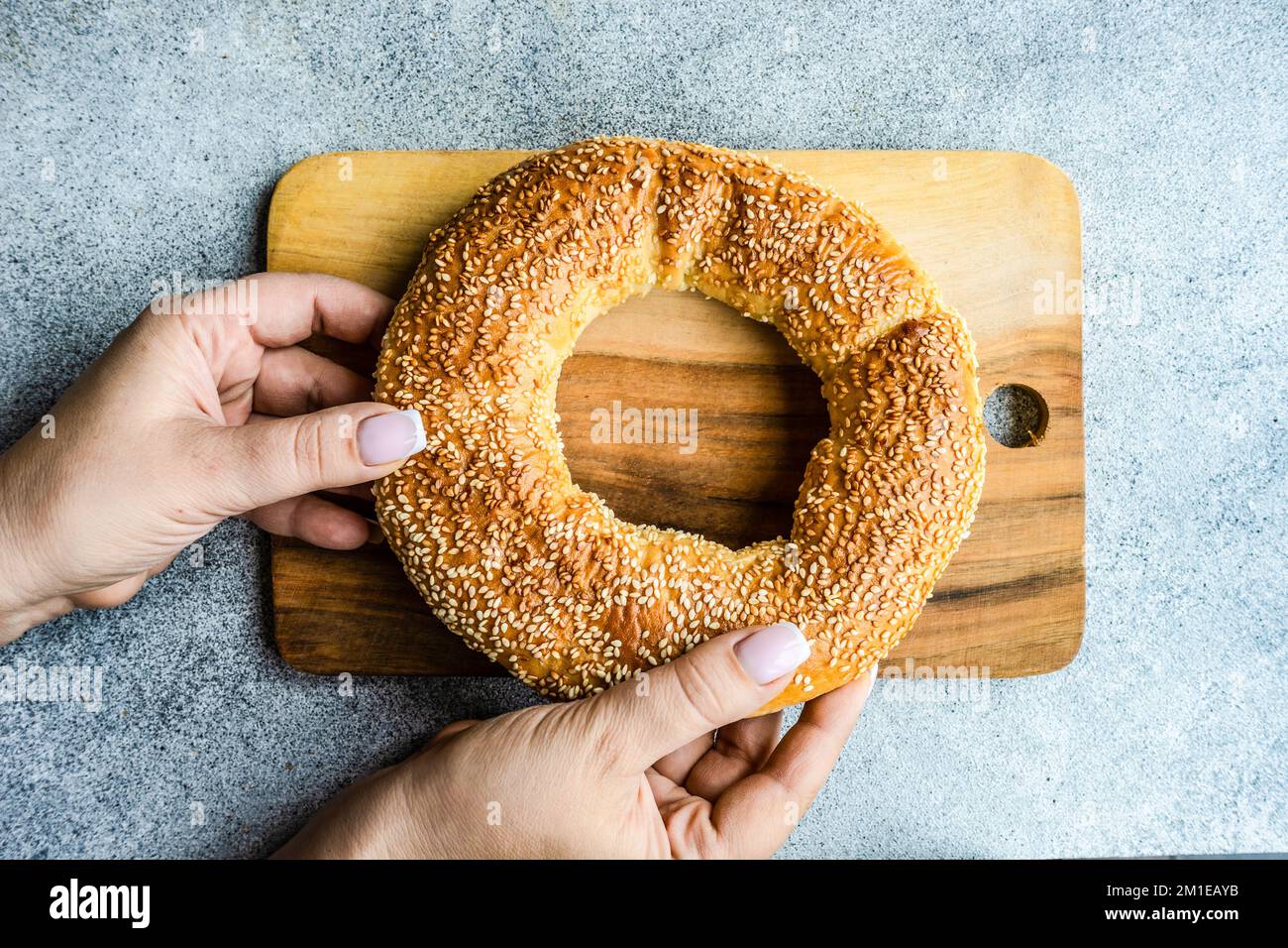 Overhead view of a woman holding a Greek sesame bread ring (koulouria) Stock Photo