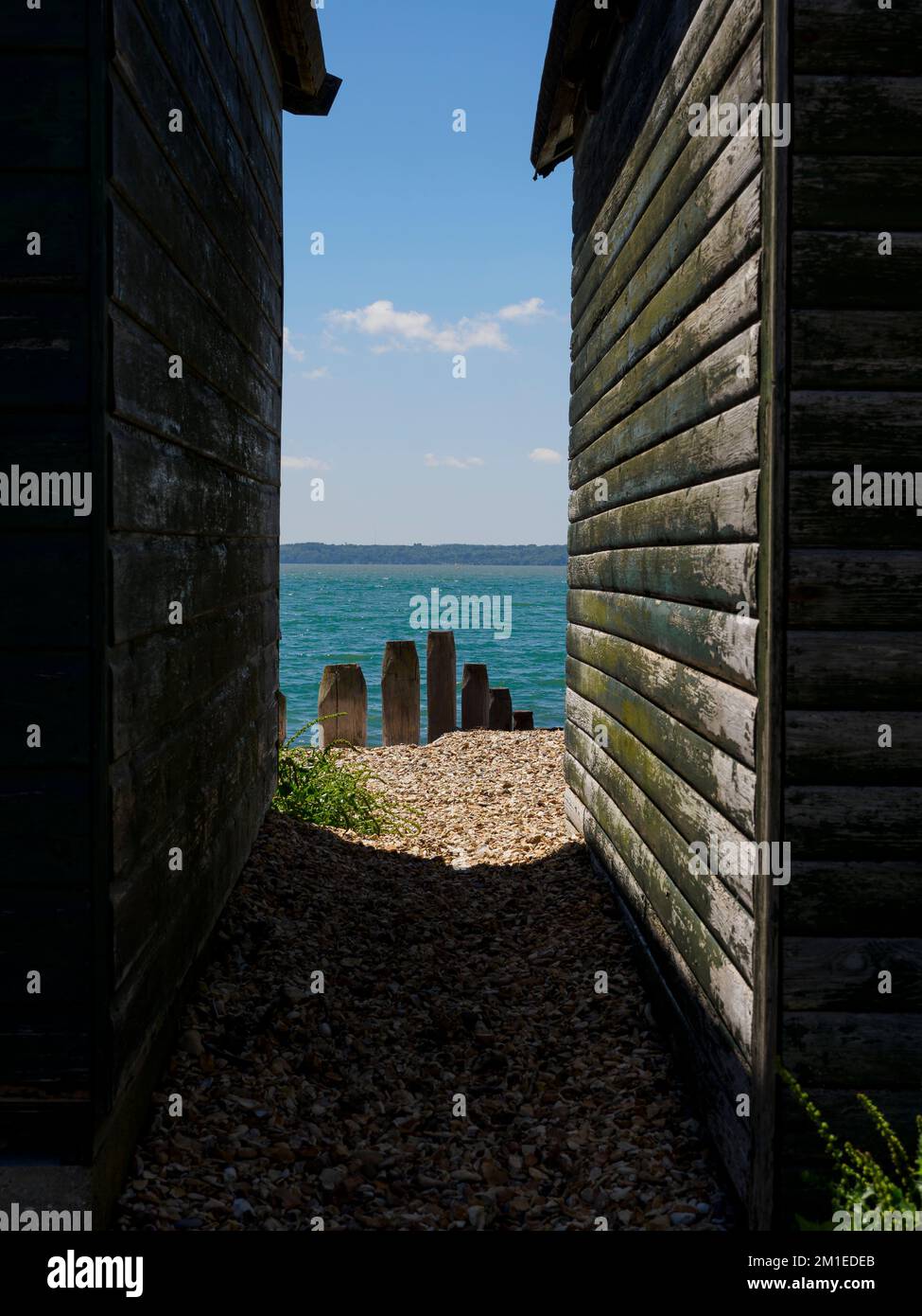 Looking between beach huts to the sea, Lee-on-the-Solent, Hampshire, UK Stock Photo