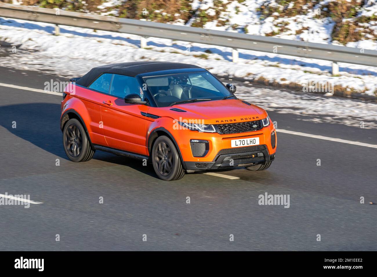2016 Orange LAND ROVER, RANGE ROVER EVOQUE TD4 HSE DYNAMIC 1999cc Diesel Cabrio; Cars travelling on a cold winter morning. Wintertime low temperatures with December frost and cold driving conditions on the M61 motorway, UK Stock Photo