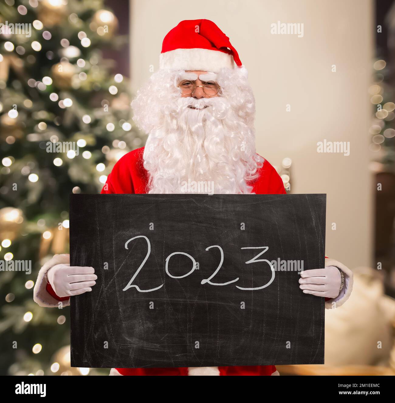 Santa Claus holding a blackboard in his hands with 2023 text Stock