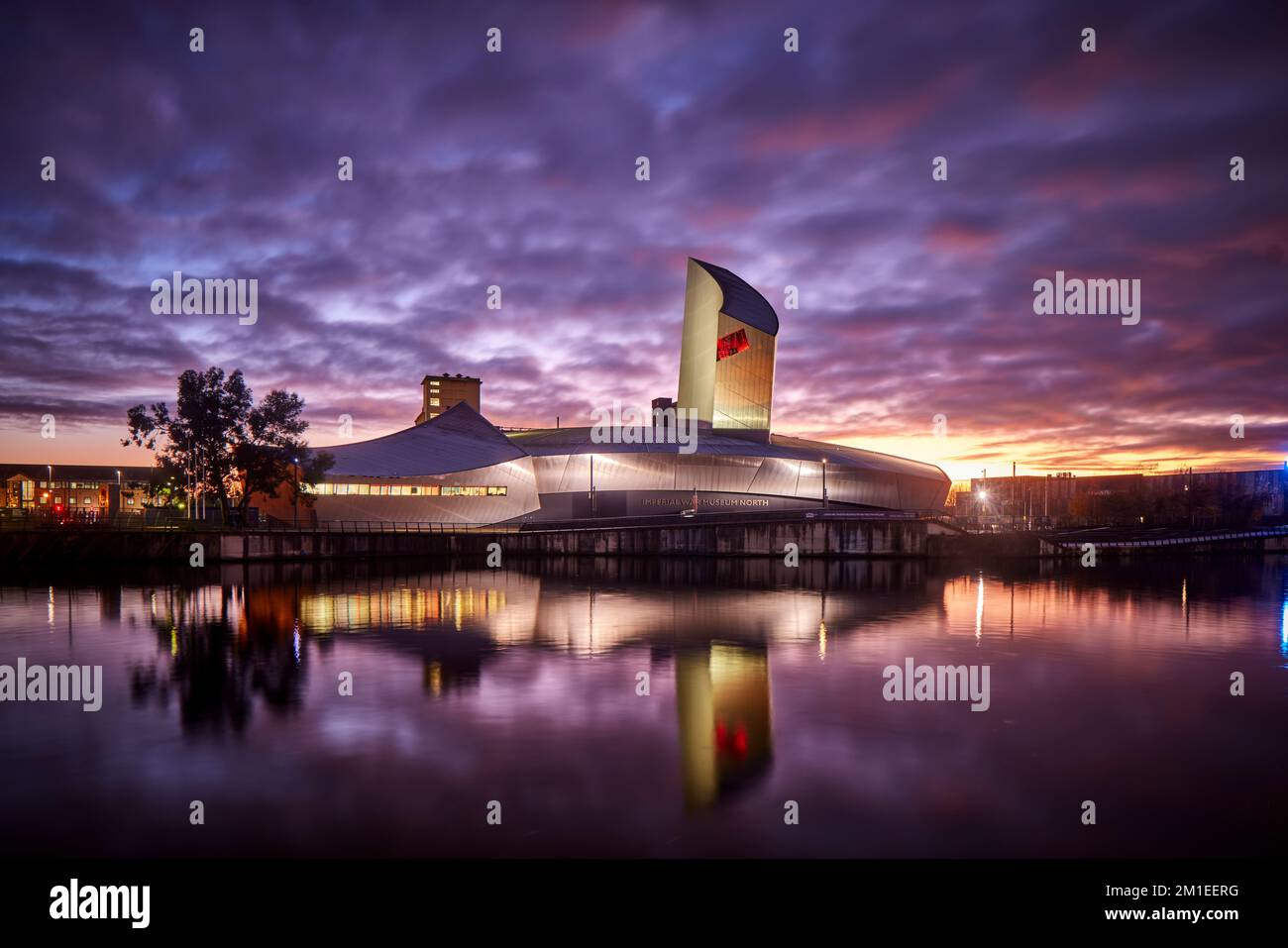 Sunset MediaCityUK Salford Quays waterfront IWM North, Imperial War Museum North by architect Daniel Libeskind Stock Photo