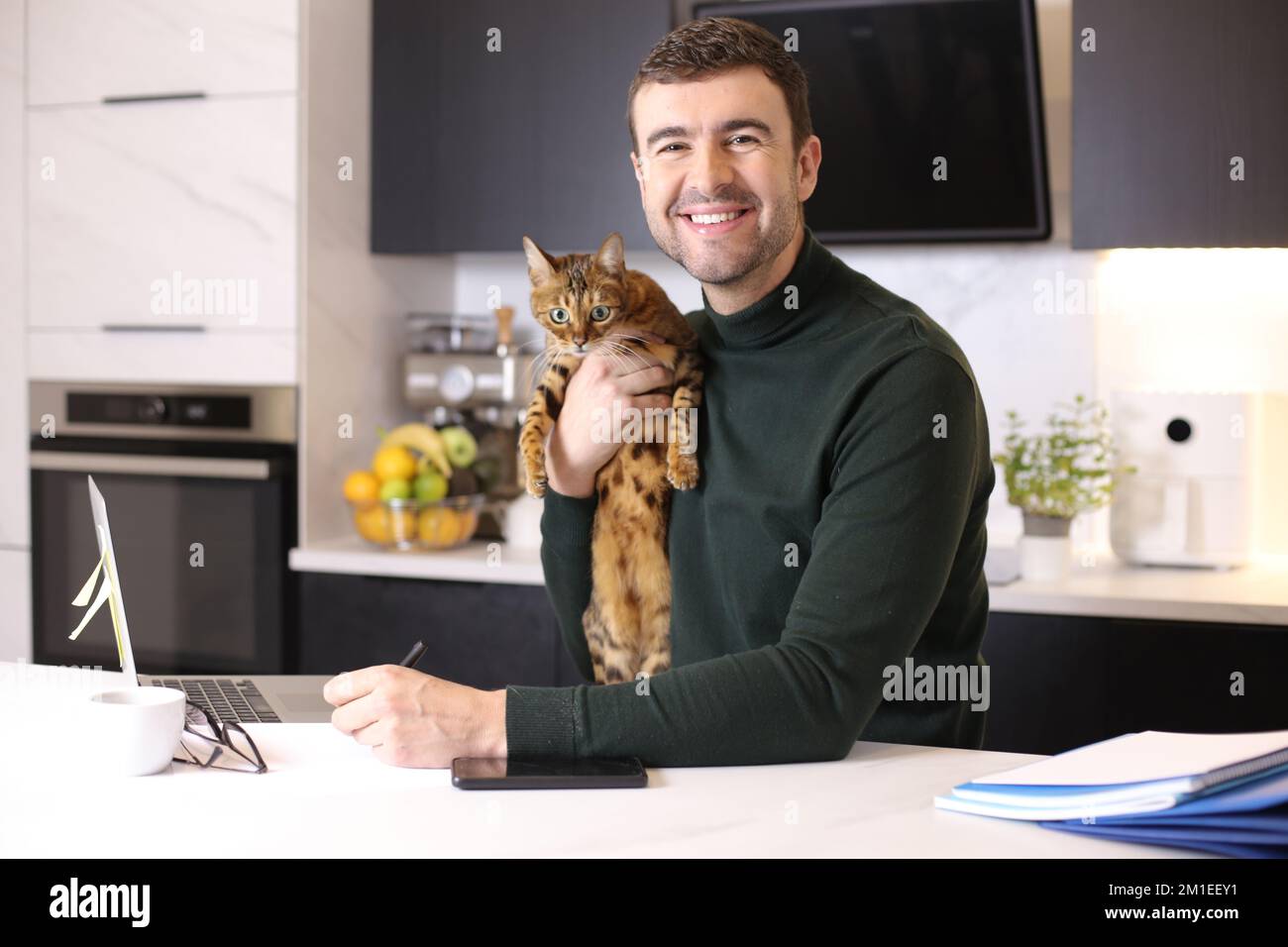 Attractive man working from home with his cat Stock Photo