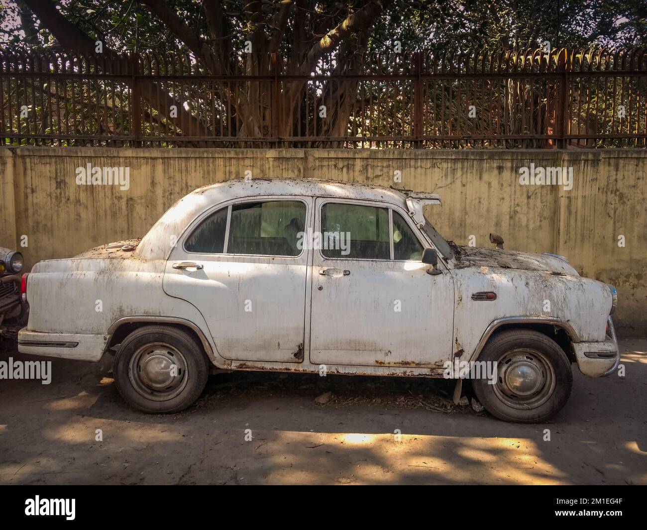 New Delhi, India - A beige vintage White Ambassador car is parked on a street Stock Photo