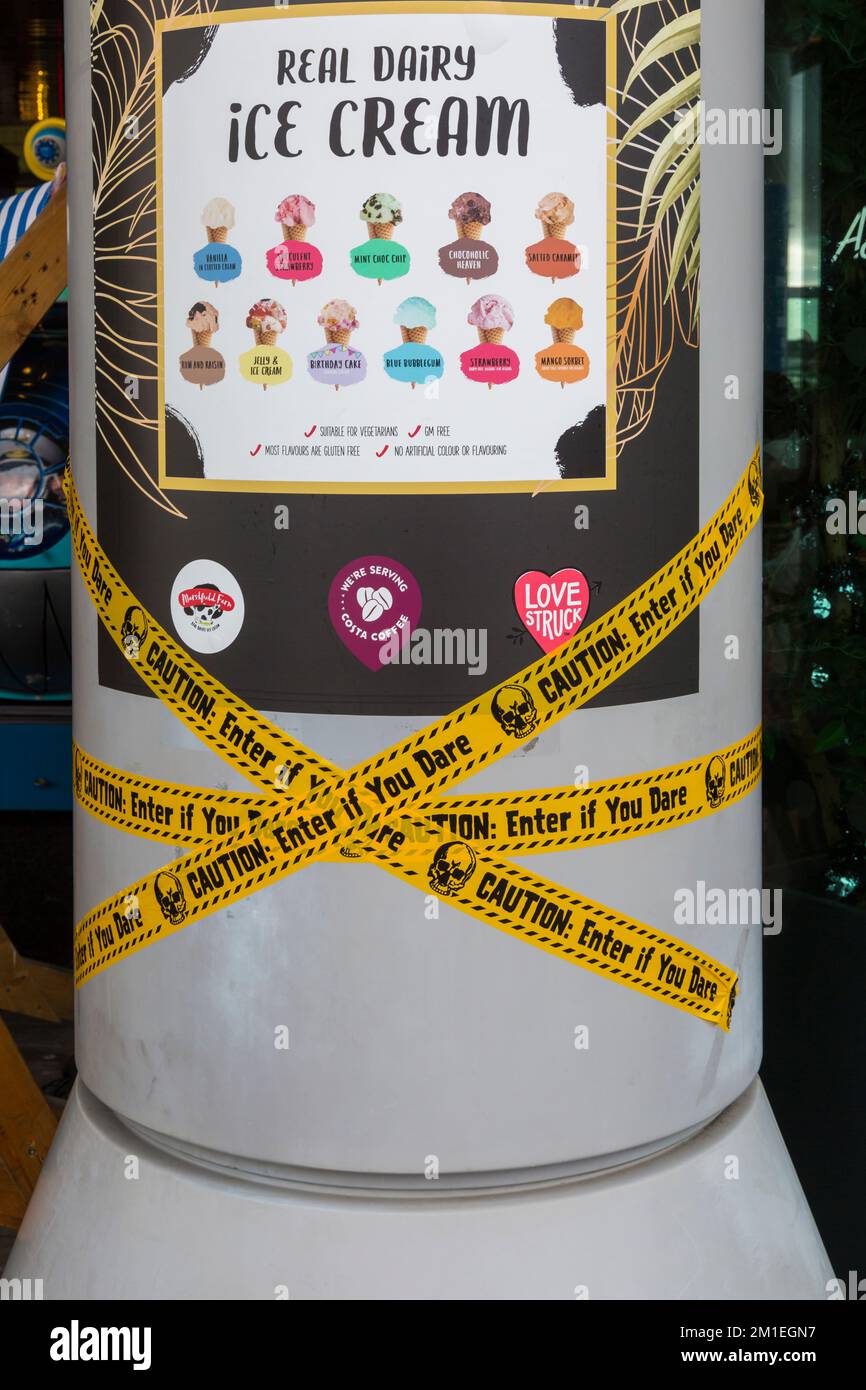 Caution enter if you dare tape with real dairy ice cream sign on pillar