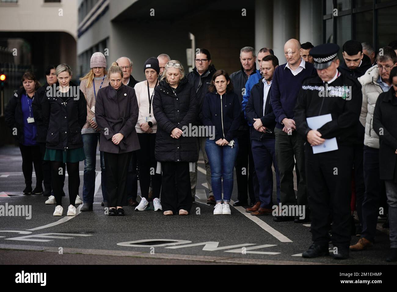 Police and public observe a minute's silence outside St Helier Police