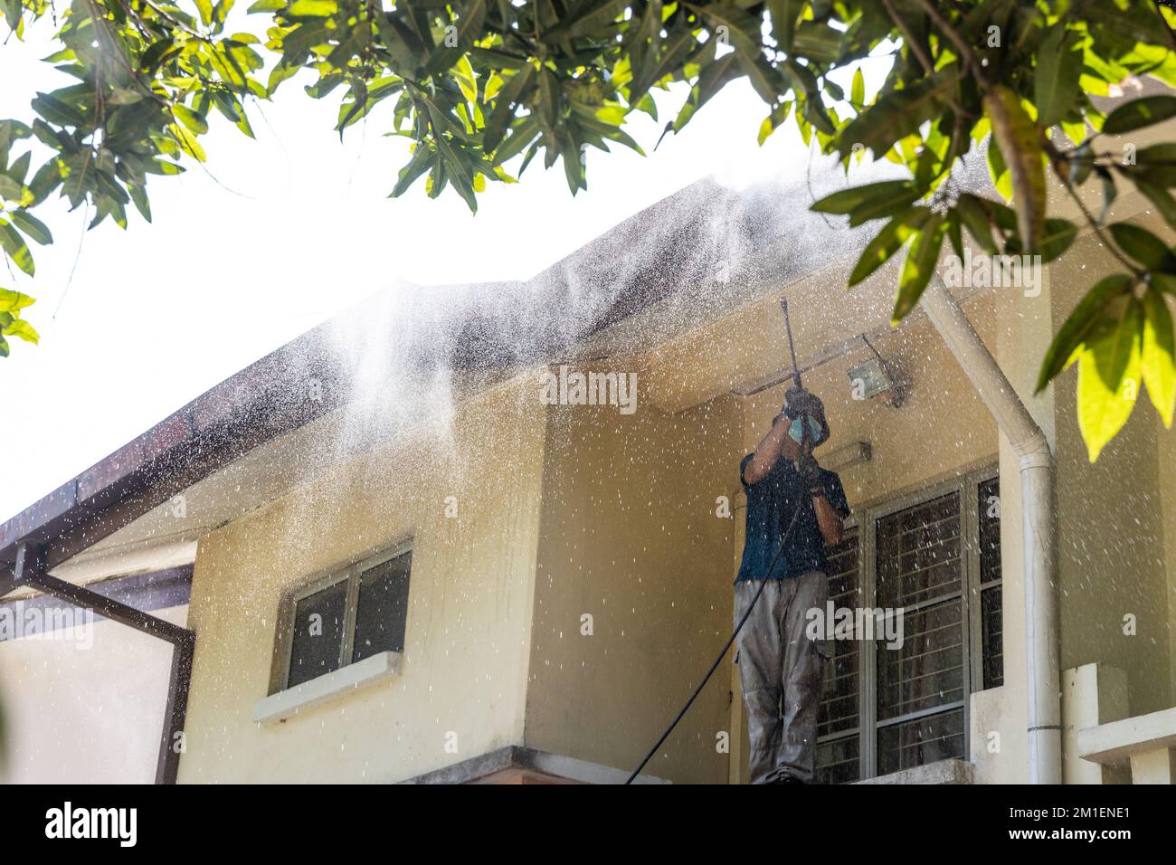 Worker using high pressure water jet spray gun to wash and clean dirt