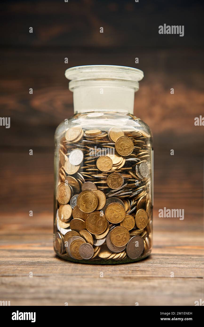 Glass jar filled of golden coins. Saving money, finance, retirement, compensation fund, investment concept Stock Photo