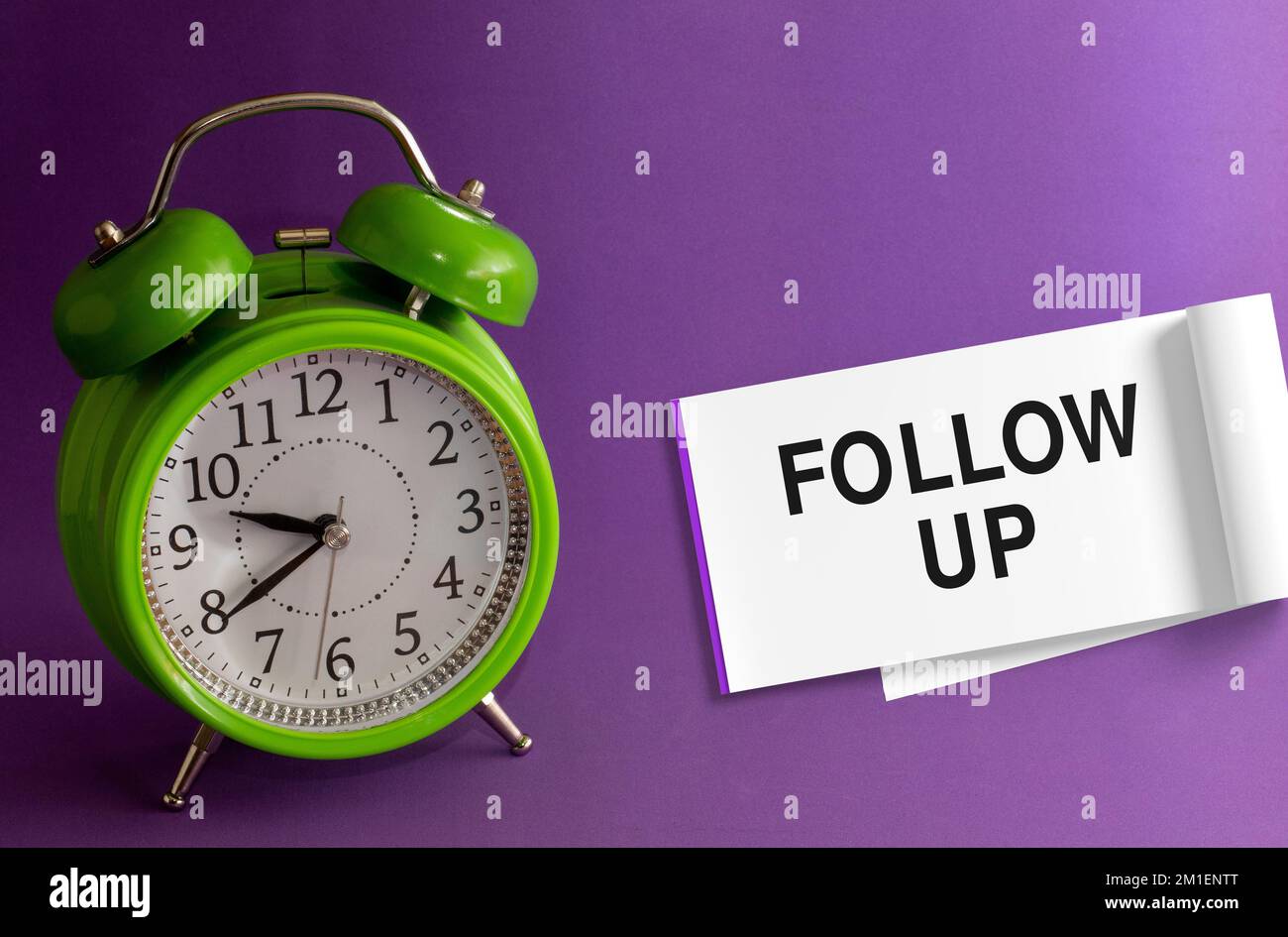 FOLLOW UP words in an office notepad purple background with a green