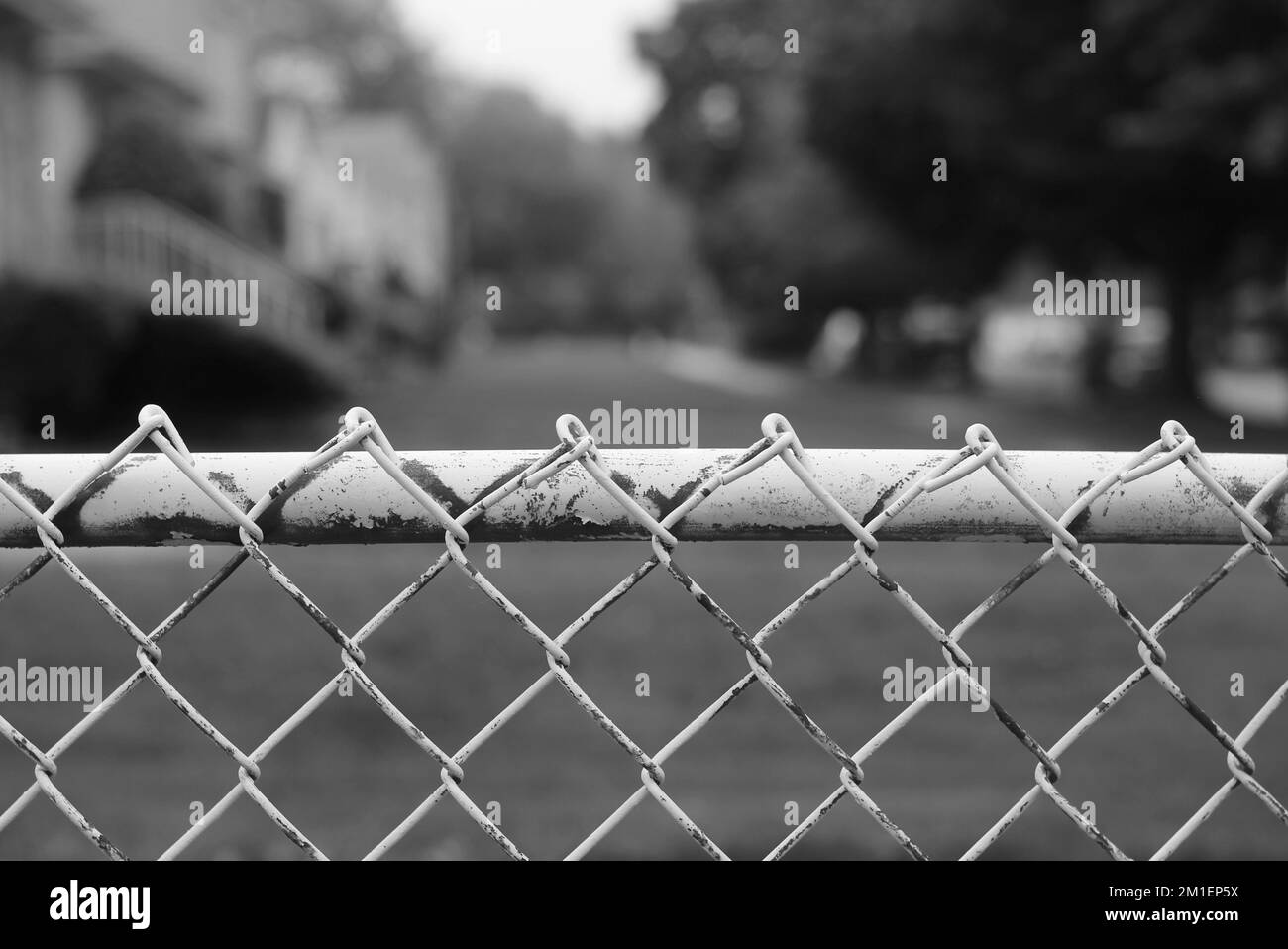 Typical vintage and rusty chain link fence crossing the yard Stock