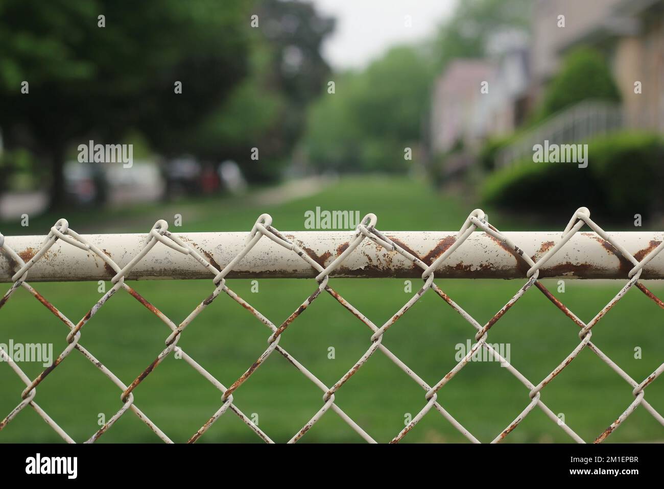 Typical vintage and rusty chain link fence crossing the yard Stock
