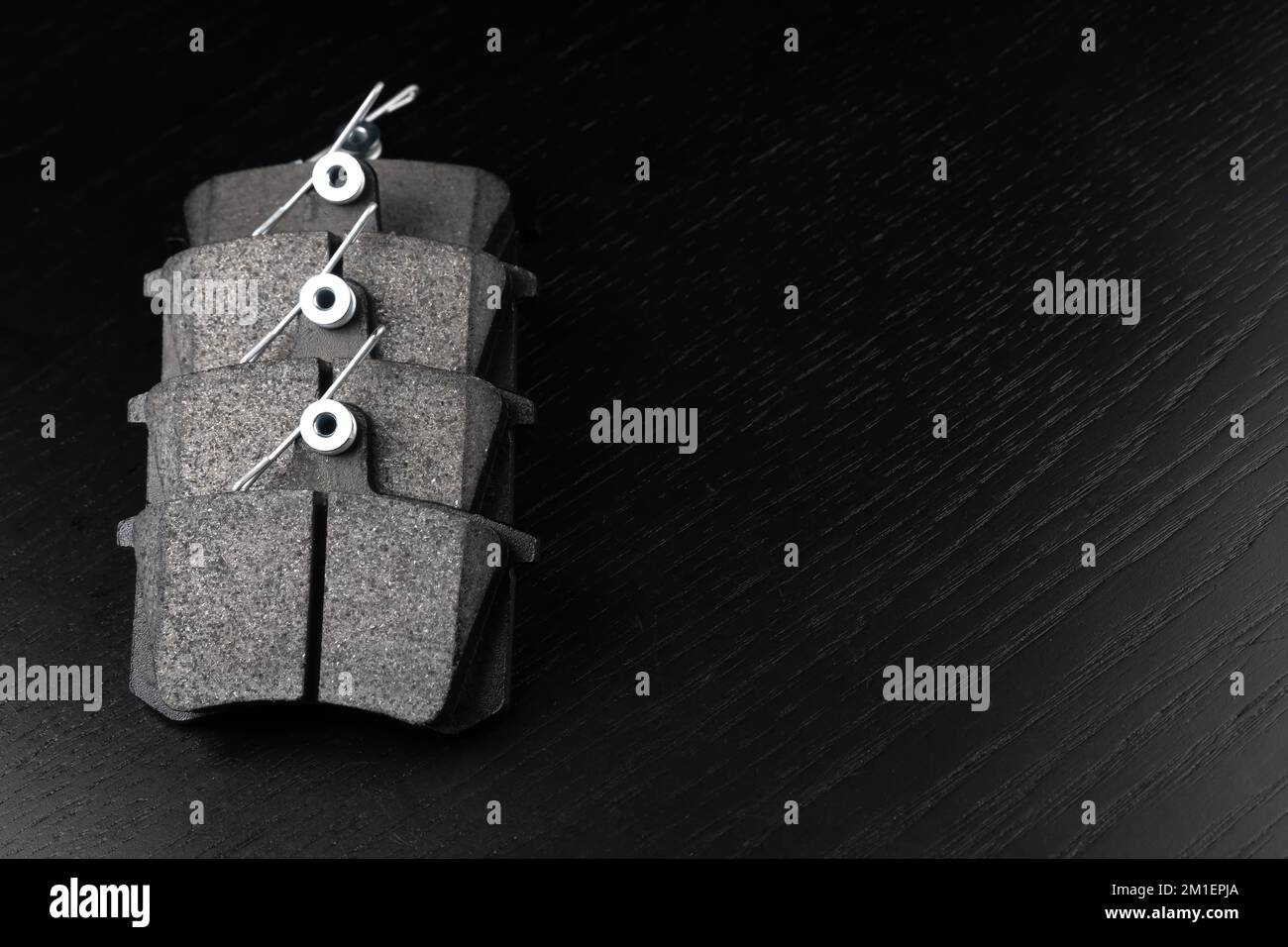 Set of new auto parts. New brake pads on a black wooden background, copy the space. A set of brake parts. Concept of a car store or car service. Stock Photo
