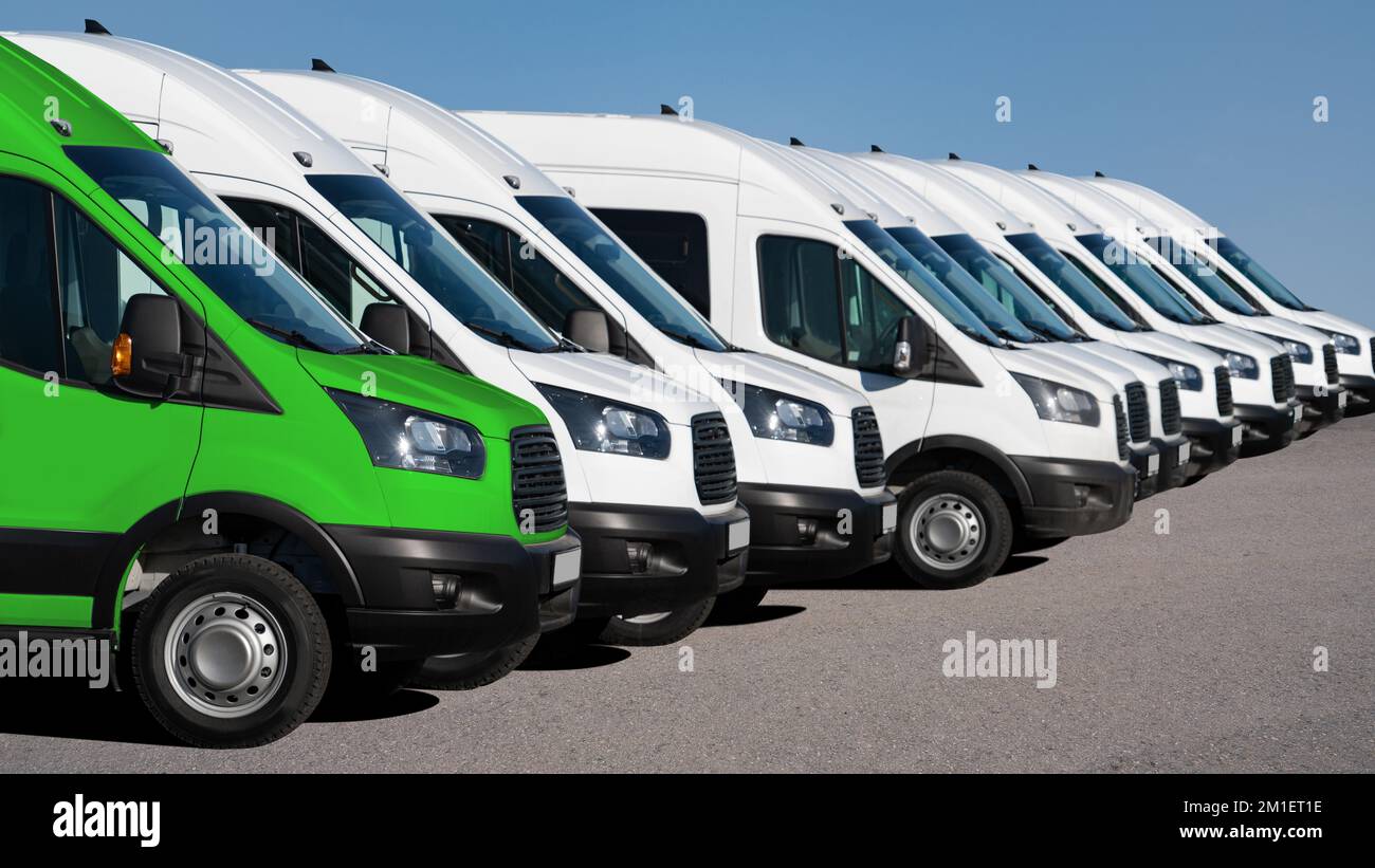Delivery vans in a row. One van green. Clean transportation concept Stock Photo