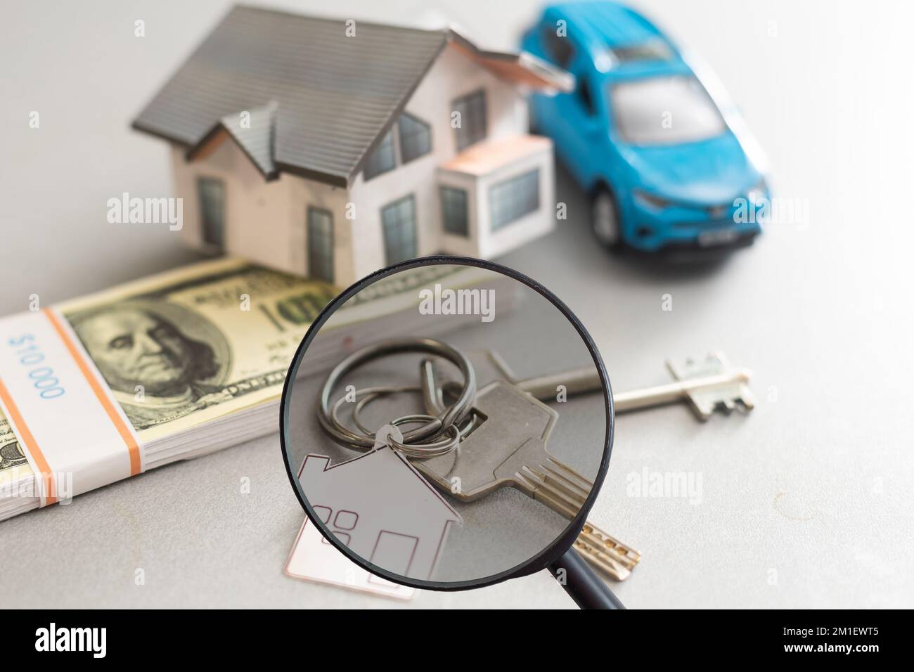 Find a home or a flat concept. Toy model house under magnifying glass ...
