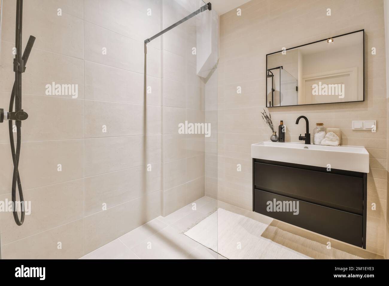 a modern bathroom with white tiles and black fixtures in the shower
