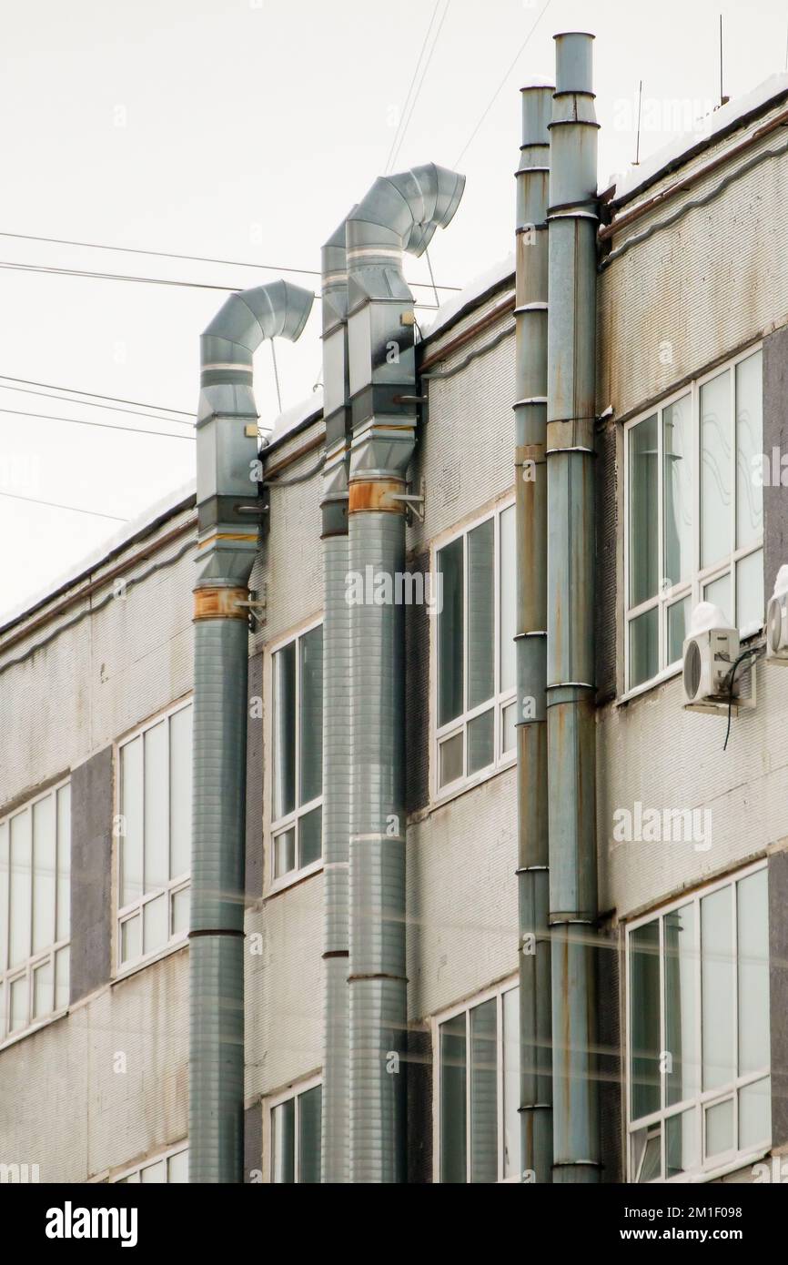Metal, long exhaust ventilation pipes on the wall of the house with