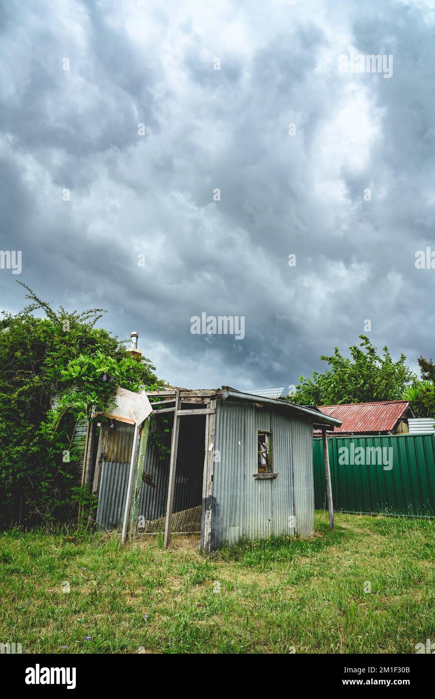 Shack stands in an abandoned lot of land in the West of Tamworth while storm clouds pass overhead. Stock Photo