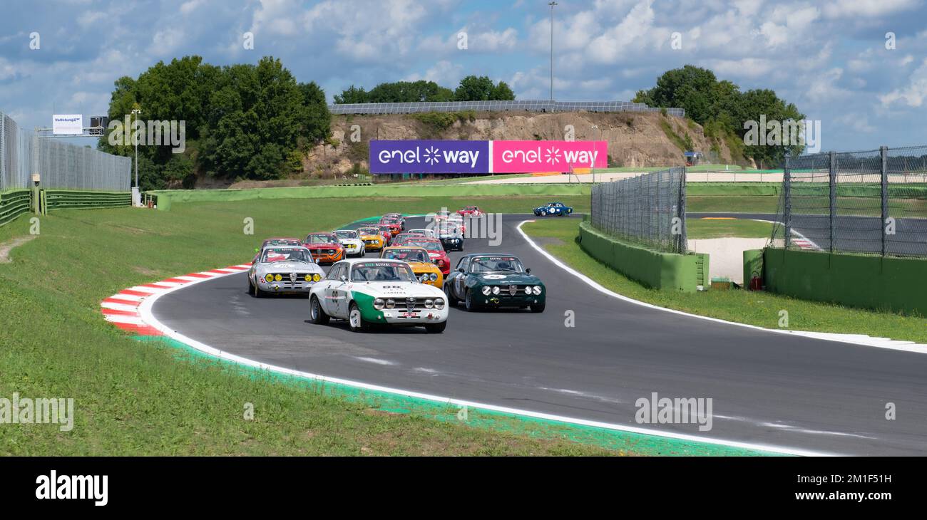 Large group of old fashioned 70s cars Alfa Romeo in action on racetrack ...