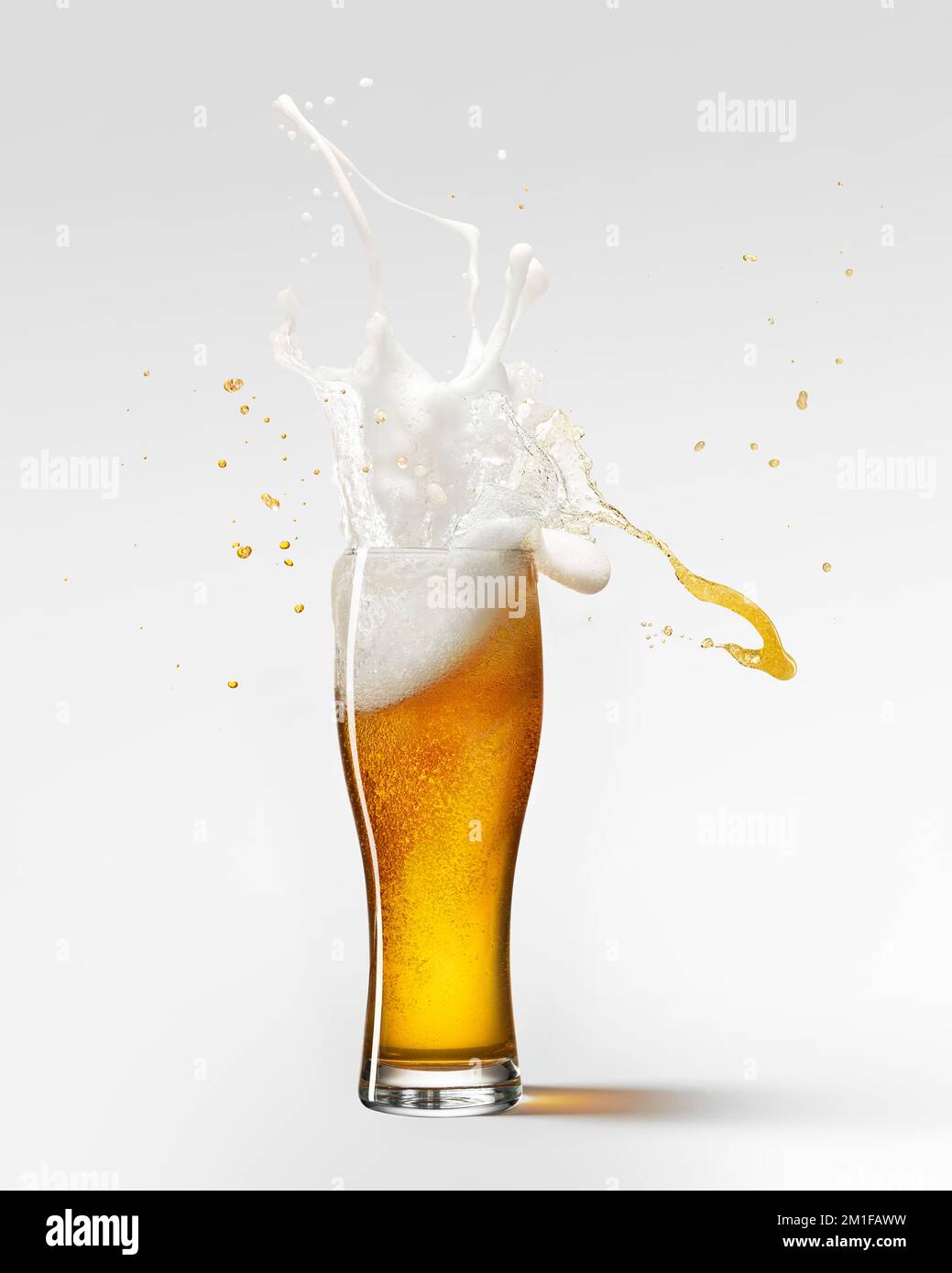 Foam splashes. Glass of delicious lager beer isolated over grey background. Beer drops. Concept of alcohol, oktoberfest, drinks Stock Photo