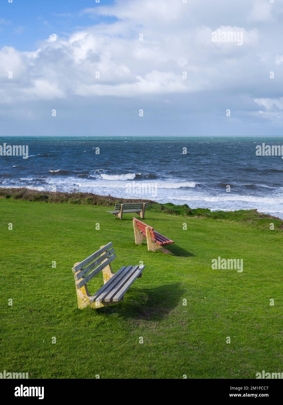 Benches overlooking Barnstable Bay on the green at Westward Ho! on the North Devon coast, England. Stock Photo