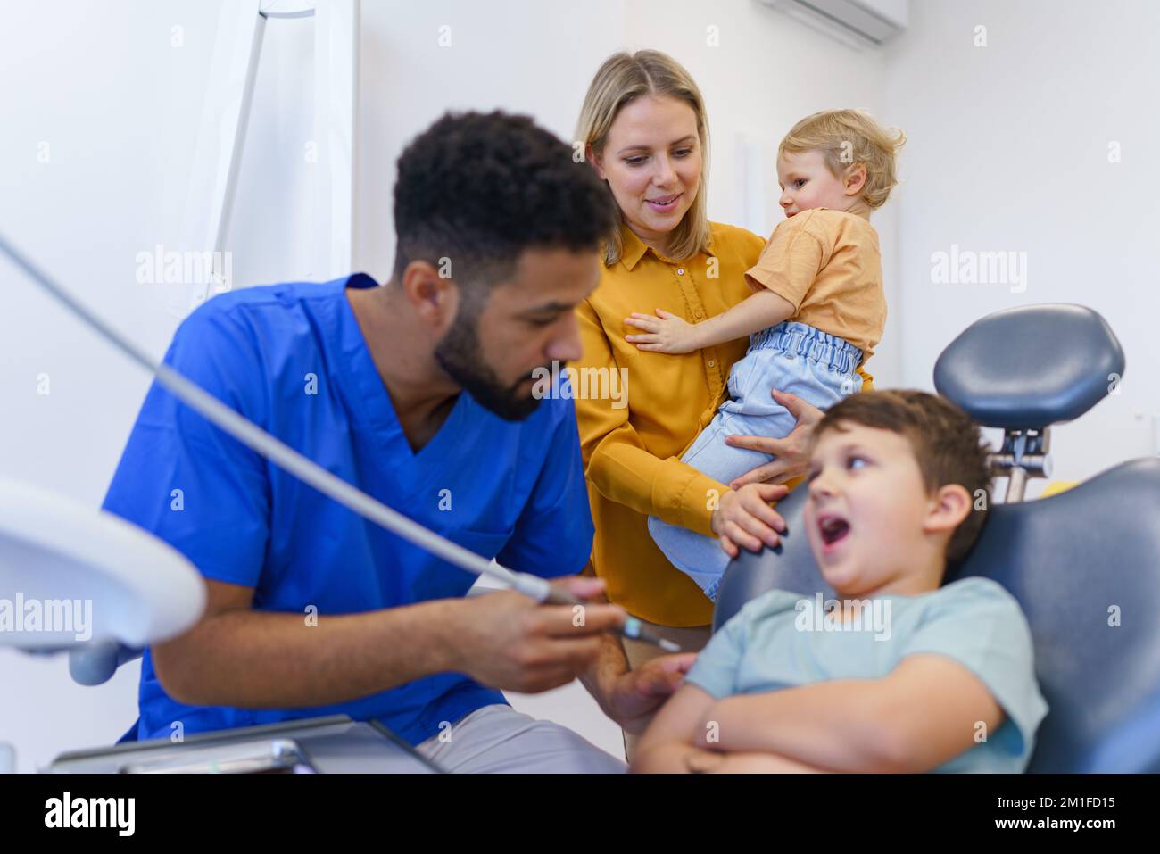 Little unhappy boy sitting in dentists chair, during examination Stock
