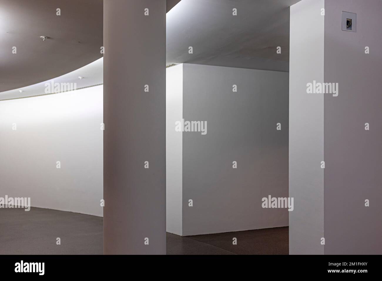 An interior shot of a modern curved hallway with columns and white walls Stock Photo Alamy