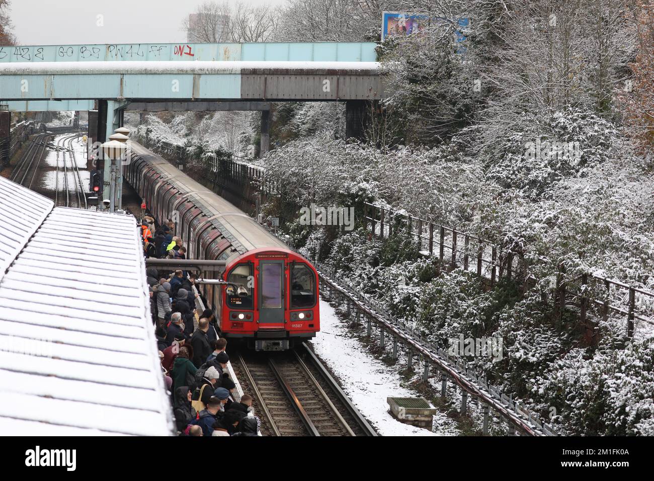 London, UK. 12th Dec, 2022. Commuters wait at the platform for a delayed train at North Acton Underground Station, west London. Snow and ice have swept across parts of the UK, with cold wintry conditions set to continue for days.. Picture date: Monday December 12, 2022. Credit: Isabel Infantes/Alamy Live News Credit: Isabel Infantes/Alamy Live News Stock Photo