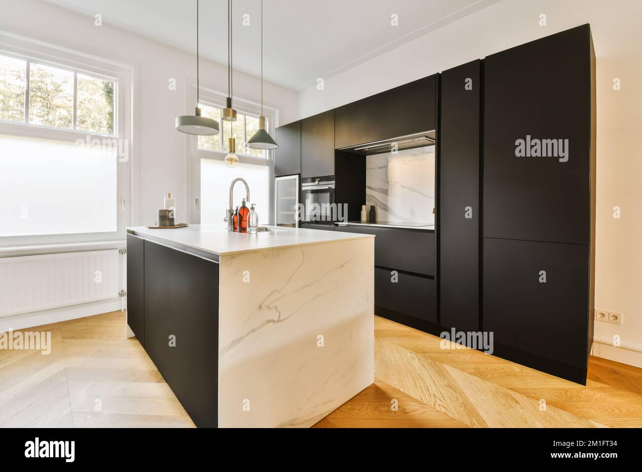 a modern kitchen with black cabinets and white marble countertops in ...