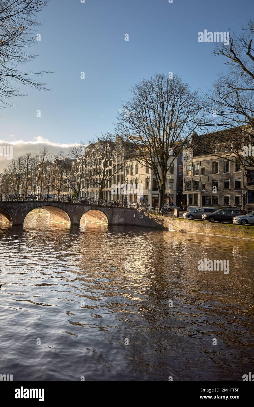 Warm winter sunshine in Amsterdam. View of the Keizersgracht canal looking South towards the bridge at Reestraat. Stock Photo