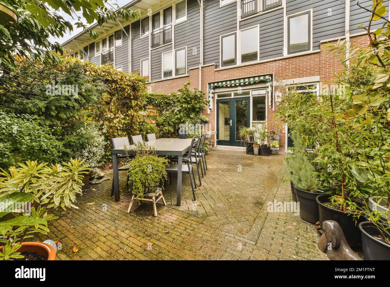 a patio with potted plants on the side and an outdoor dining table in ...