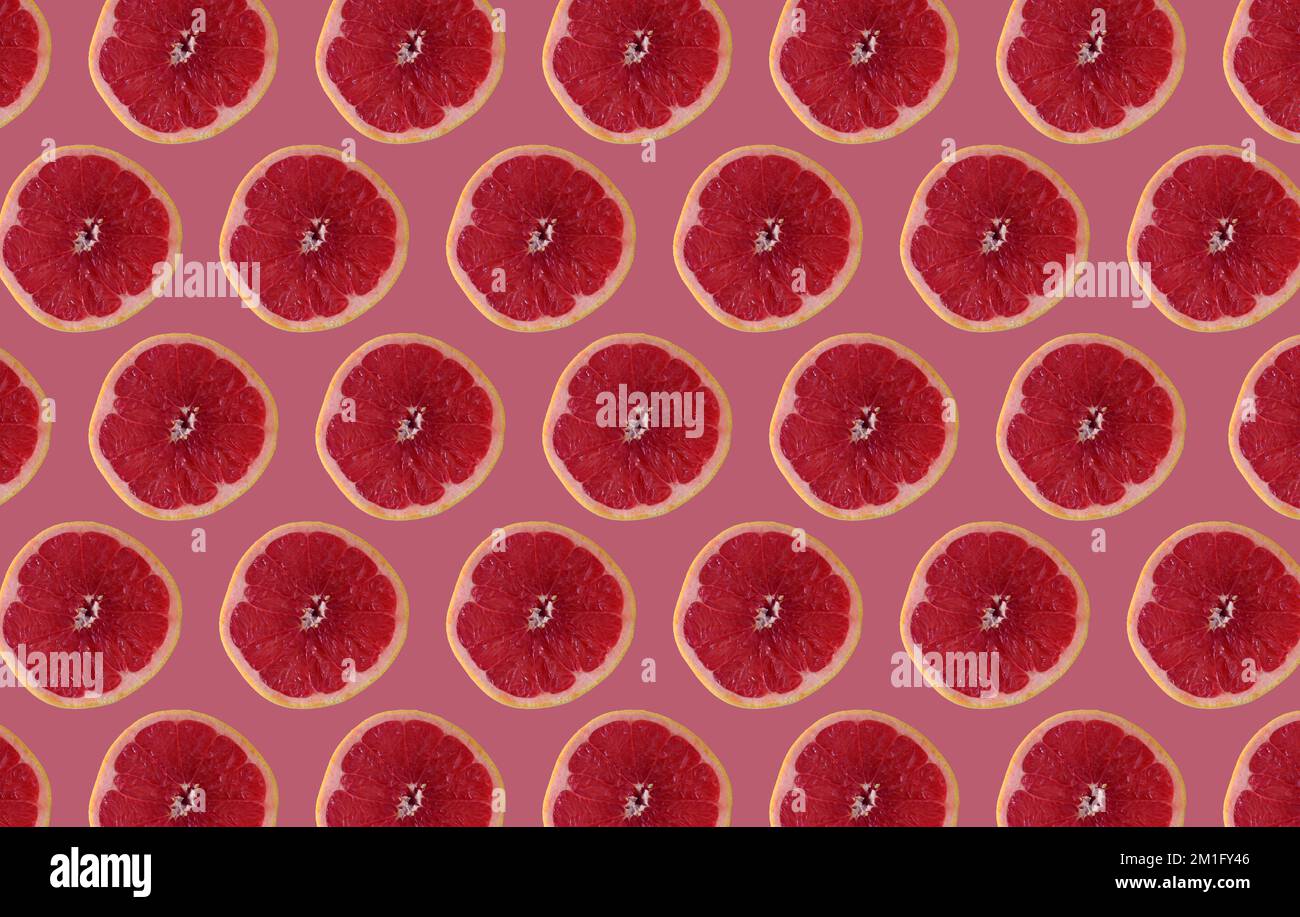 Cut grapefruit slices isolated on pink background. Citrus concept idea. Stock Photo