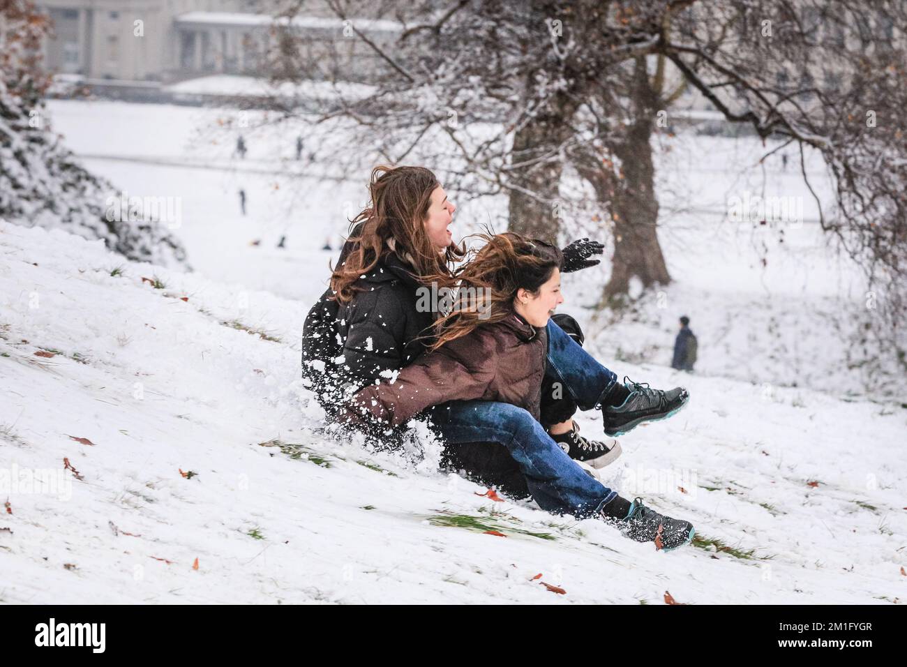 London, UK. 12th Dec, 2022. People in Greenwich Park have fun in the snow with the many snow covered hills of the Royal Park providing ample place for walkers and those who want to sledge, go tobogganing, and even snowboard. Credit: Imageplotter/Alamy Live News Stock Photo