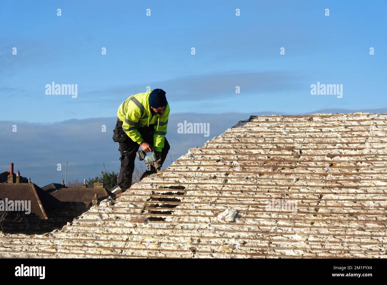 Builder removing hardened spray foam insulation from the roof space of