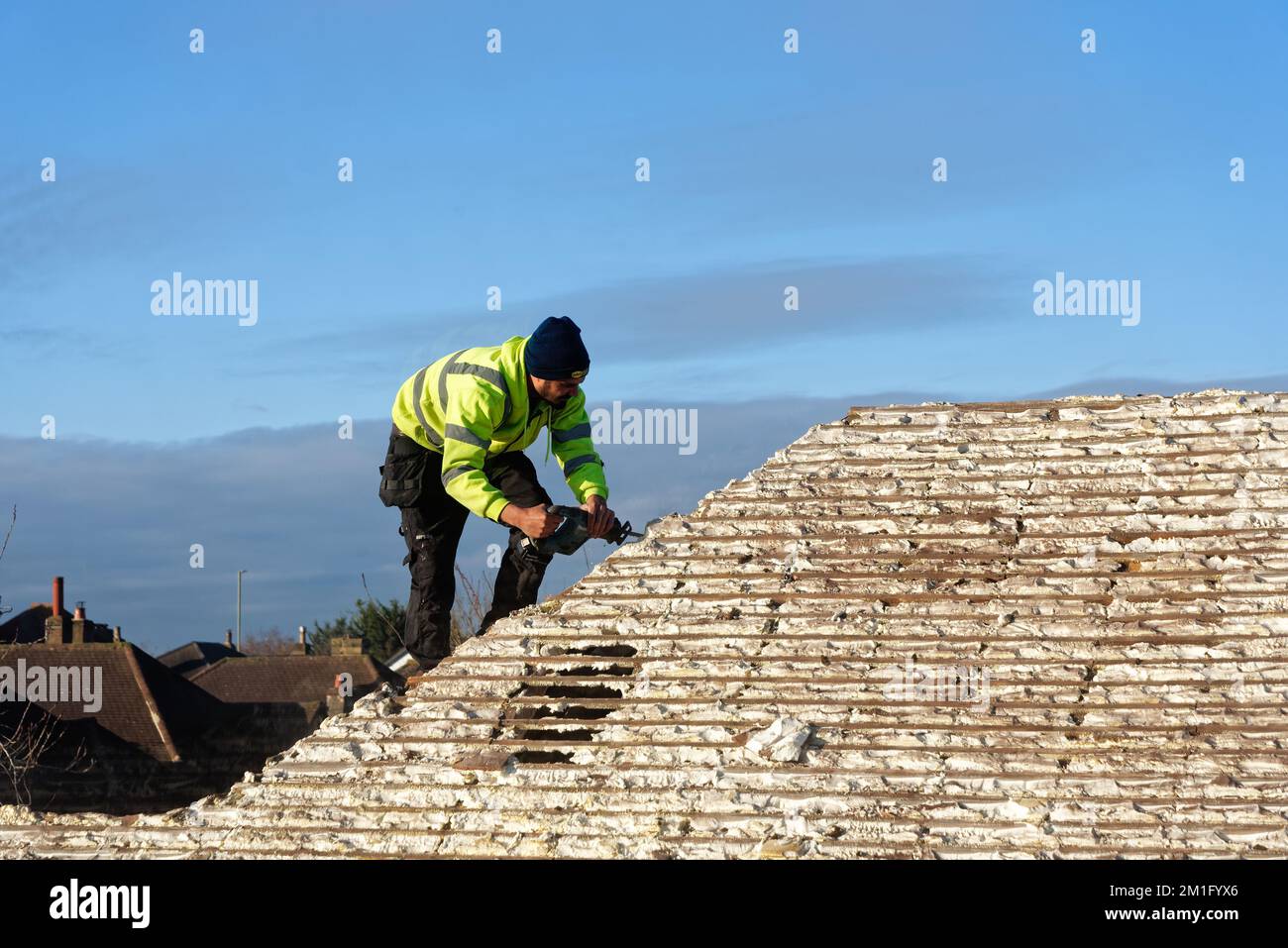 Builder removing hardened spray foam insulation from the roof space of